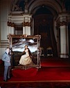 With a painting of the Queen in the throne room